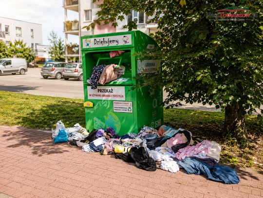 Ubrania zalegają na chodnikach. Kto pilnuje pojemników na używaną odzież?