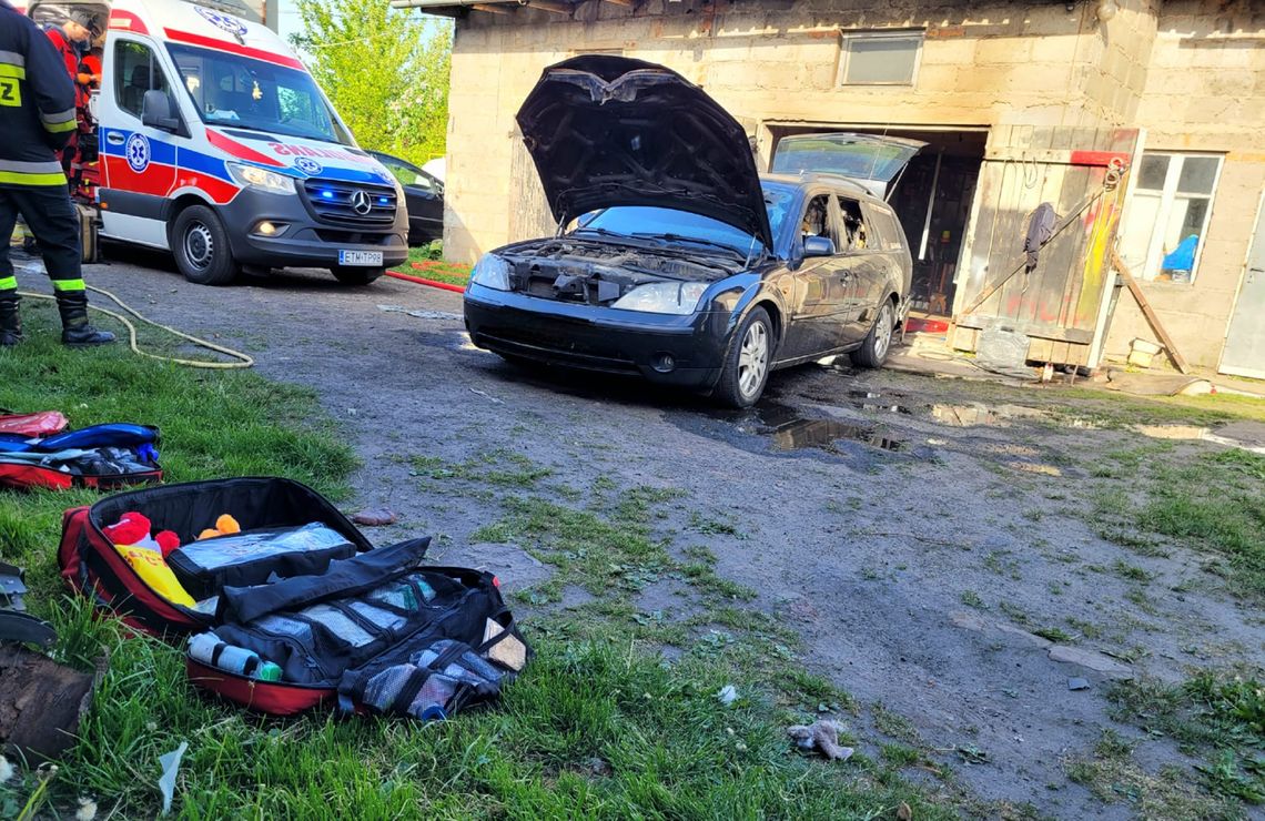 Palił się garaż i samochód. Strażacy pomagali poparzonej osobie 