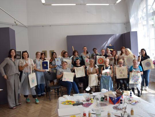 Uczestnicy warsztatów „Kreatywny upcykling” w Muzeum w Tomaszowie Mazowieckim pokazują torby z malowanymi mandalami.