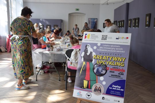 Sala Muzeum w Tomaszowie Mazowieckim; uczestnicy malują tkaniny, na pierwszym planie plakat „Kreatywny upcykling”.