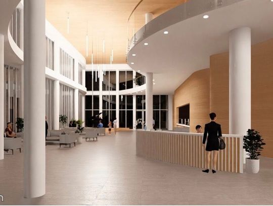 Jasne foyer sali koncertowej z recepcją, wysokim sufitem z drewnem i pionowymi lampami, widoczne przeszklenia i strefa siedząca.