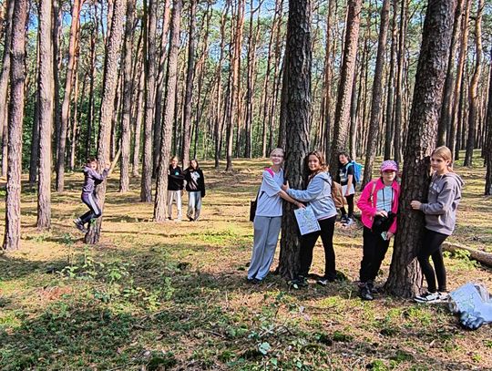 Moc drzew – uważność w praktyce Grupa uczennic przytula sosnę podczas kąpieli leśnych – zdrowy styl życia w Tomaszowie Mazowieckim