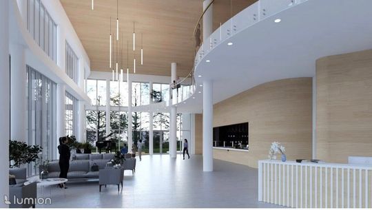 Duże foyer z kanapami, fortepianem i wnęką kawiarni po prawej, nad całością biegnie balkon.