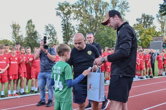 Wspólny okrzyk „Lechia Tomaszów!” – trenerzy i zawodnicy z uniesionymi rękami na bieżni Stadionu Miejskiego podczas Narodowego Dnia Sportu.
