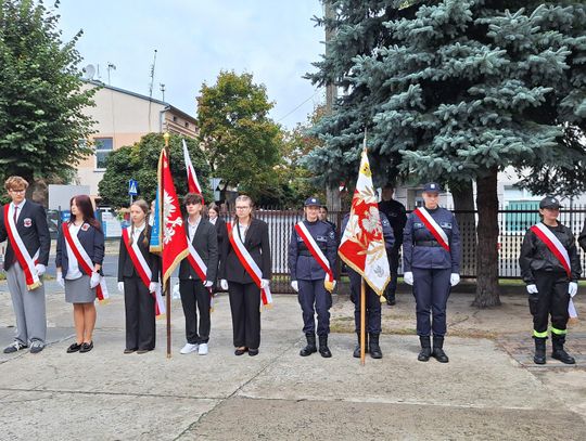 Szkolne i mundurowe poczty sztandarowe ustawione przy miejscu pamięci