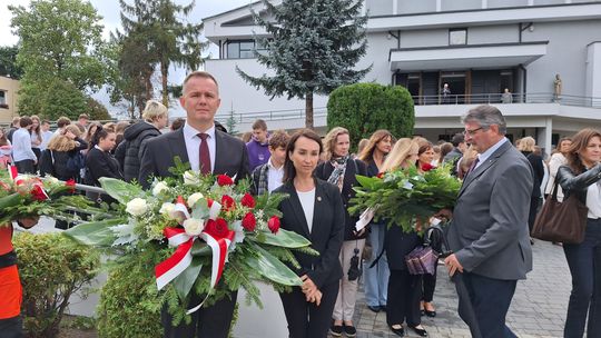 Delegacja z wieńcami przed kościołem, uczestnicy zgromadzeni na placu
