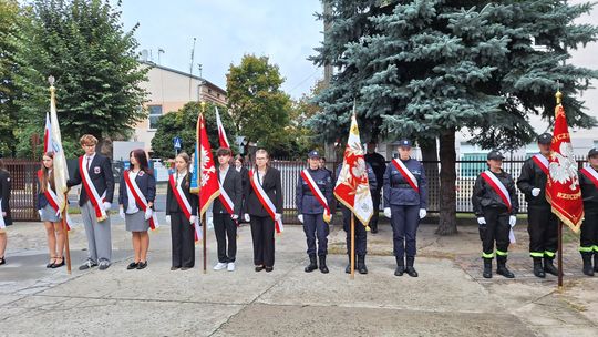 Szkolne i mundurowe poczty sztandarowe ustawione przy miejscu pamięci