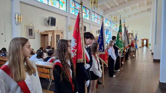 Młodzież z pocztami sztandarowymi w nawie kościoła