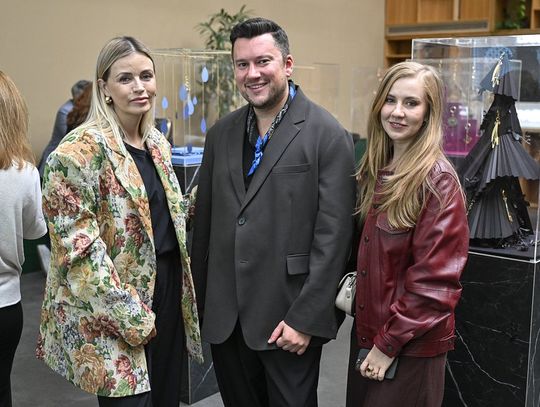 Trzy osoby przy gablocie z brelokami z limitowanej kolekcji.