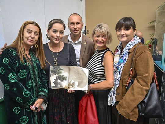 Pięć osób prezentuje otwarty album podczas premiery kolekcji.