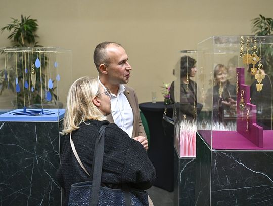 Dwoje gości ogląda gabloty z brelokami i biżuterią ORSKA x PARADYŻ w przestrzeni wystawowej.