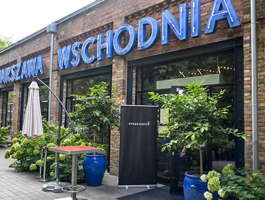 Wejście do restauracji Warszawa Wschodnia z szyldem i roll-upem Paradyż przed lokalem.