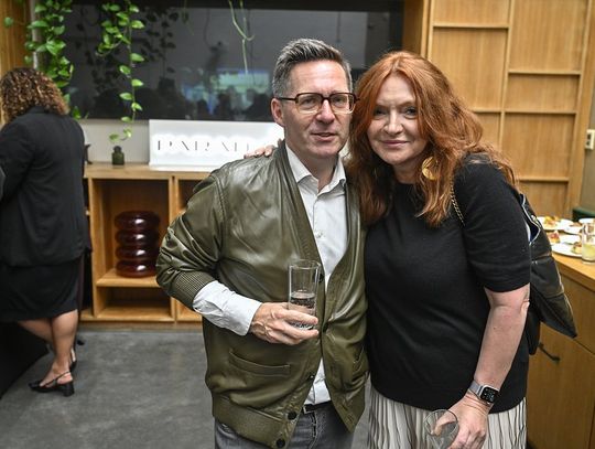 Dwie osoby pozują podczas premiery kolekcji ORSKA x PARADYŻ; w tle logo marki.