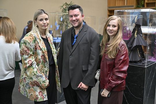 Trzy osoby przy gablocie z brelokami z limitowanej kolekcji.