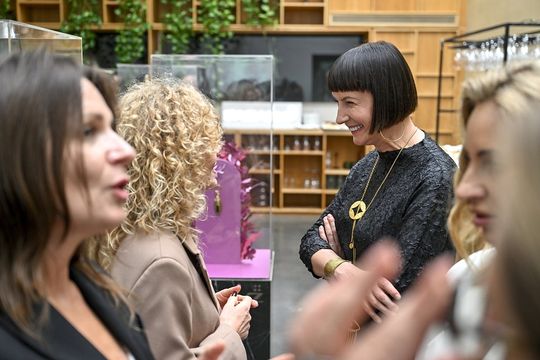 Rozmowy o designie – przy gablotach z brelokami Uczestniczki wydarzenia rozmawiają wśród ekspozytorów ORSKA x PARADYŻ.