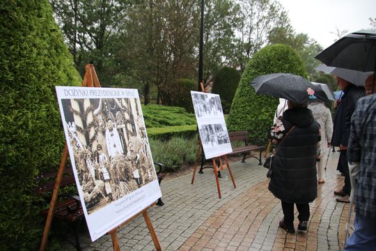 Wystawa pod chmurką – spacer wśród plansz Grupa z parasolami ogląda plenerową wystawę plansz w parku.