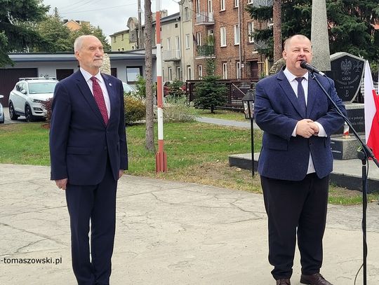 Wystąpienia przy pomniku; uczestnicy uroczystości słuchają przemówień w plenerze.