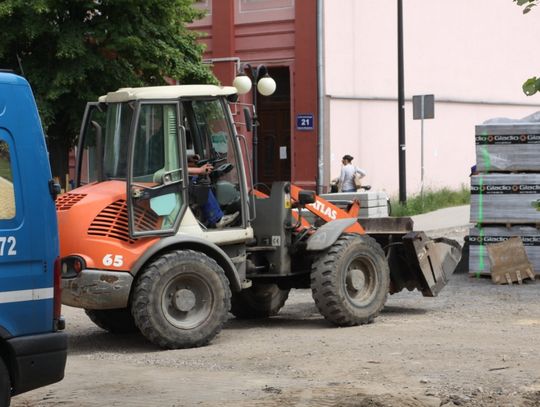 Między nimi jeździ ciężki sprzęt budowlany. 